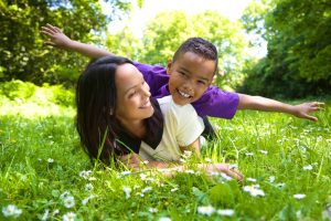 Portrait of a happy mother and son playing outdoors in the park