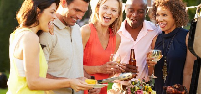 Mature Friends Enjoying Outdoor Summer Barbeque In Garden