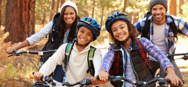 Portrait Of Family Cycling Through Fall Woodland