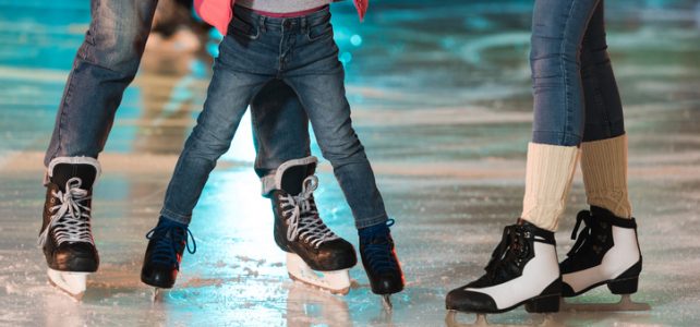 family in skates skating together on rink